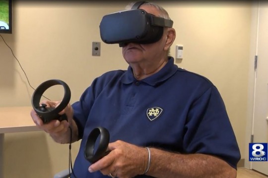 Senior citizen uses VR goggles.
