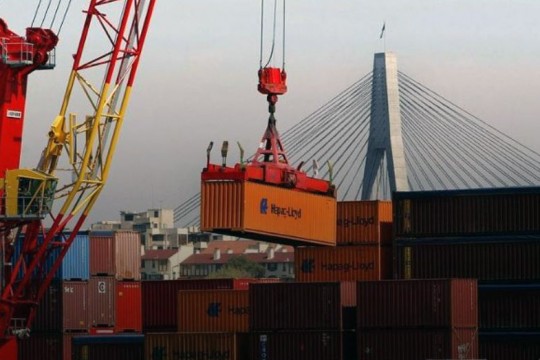Crane hoisting shipping container.