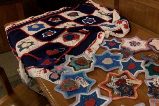 Knit quilt made of hearts inside of Stars of David.