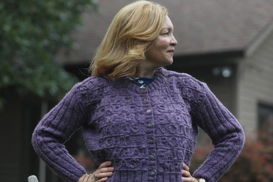 Woman wearing purple cardigan sweater.
