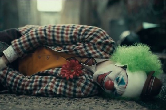 Screenshot from "Joker" movie with clown laying on the ground.