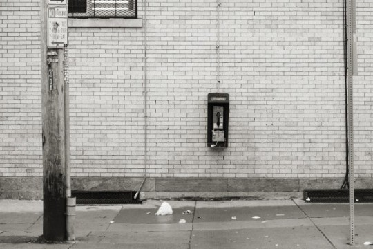 Payphone on a brick wall.