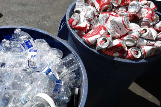 two buckets of crushed water bottles and beer cans.