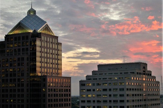 tops of two tall buildings at dusk.