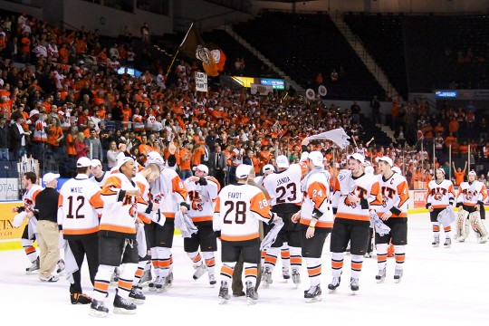 hockey players on ice celebrating win.
