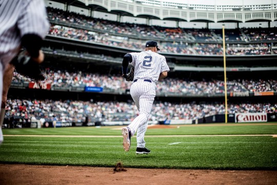 backside of New York Yankee player Derek Jeter as he jogs onto the field.