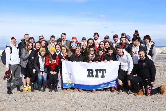 team of students on beach of Lake Ontario in winter.