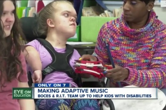 student with disability playing a tambourine.