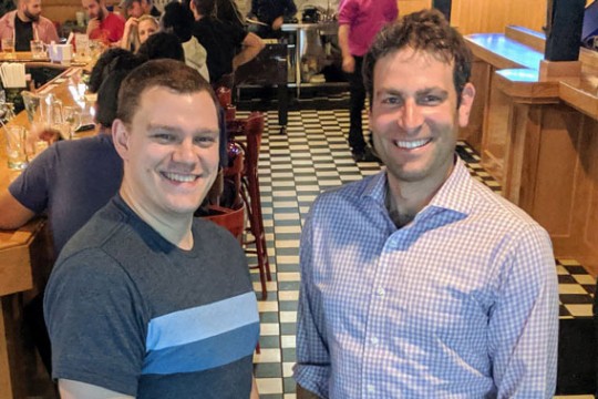 two men standing in restaurant.