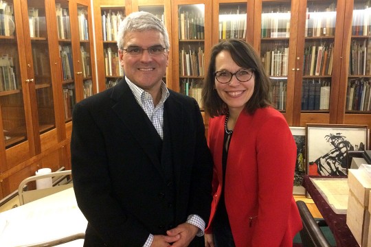 dean and professor standing in library.