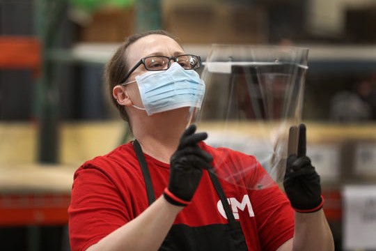 woman inspecting plastic face mask.