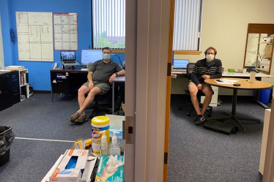 two men sitting in adjacent offices.