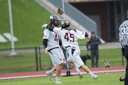 two lacrosse players celebrating.