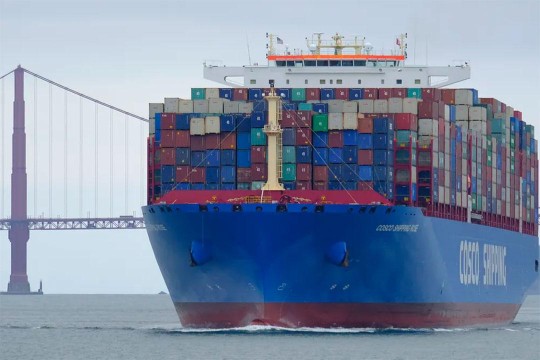 cargo ship with stacks of colorful shipping containers.