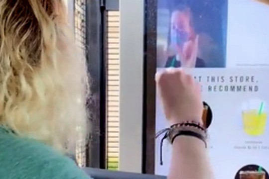 customer and employee using sign language at a Starbucks drive-through.