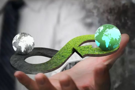 illustration of hand holding a figure-eight symbol with two globes on either end.