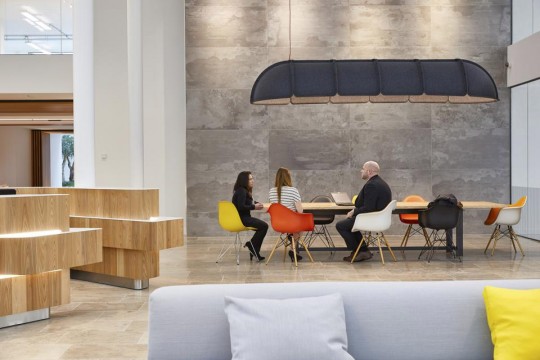 three people having a meeting in a modern workspace.