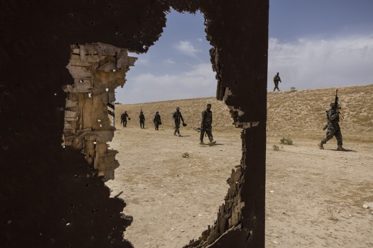 A group of soldiers march in the Afghanistan desert.