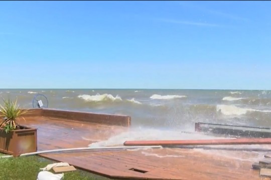 waves crashing over a breakwall.
