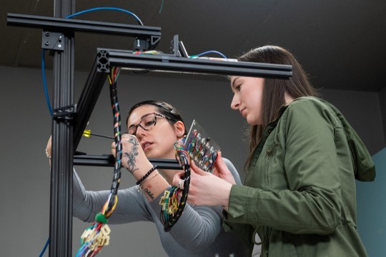 two students adjusting an imaging system.