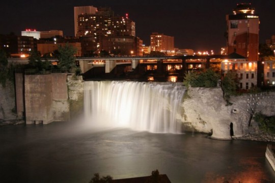 nighttime view of a waterfall in the city of Rochester.