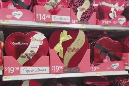 grocery store shelves with heart-shaped boxes of chocolates.