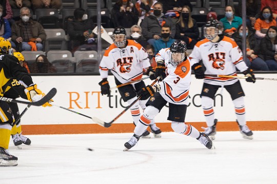 three RIT men's hockey players playing on the ice.
