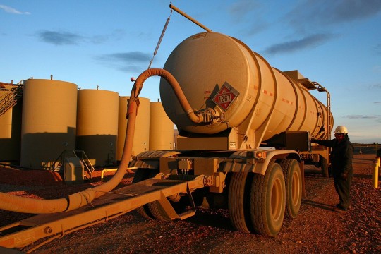 oil tank truck hooked up to a hose.