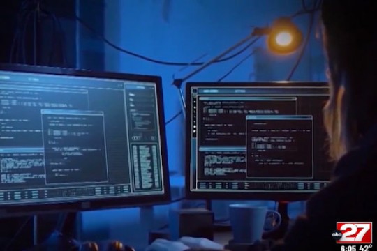 person looking at computer programs on two monitors.