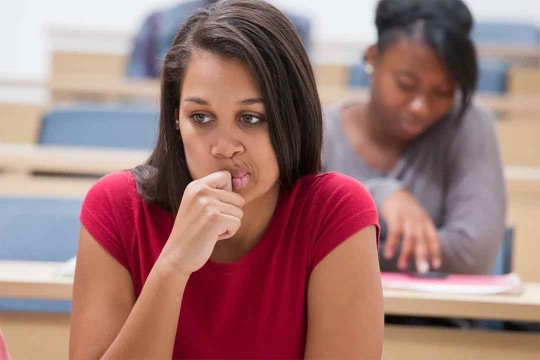 student with a worried expression on her face.