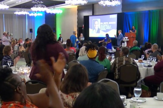 room of people applauding for an award winner.