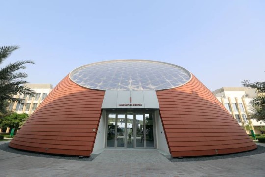 A conical building with a flat, glass roof designed to resemble the core of a quantum microchip.