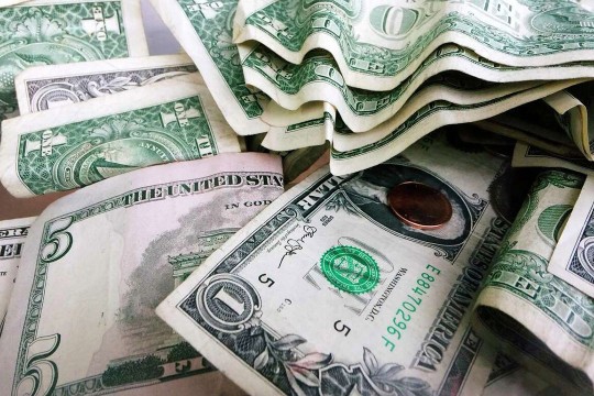 a pile of 5 and 1 dollar bills.