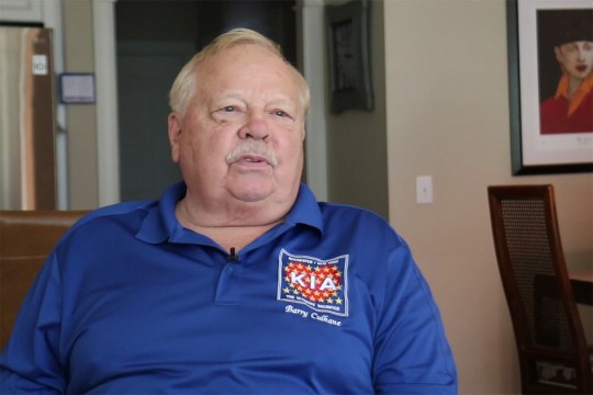 retiree sitting in a chair being interviewed.