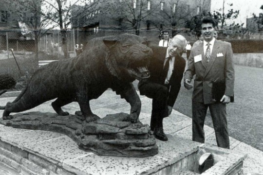 former president Jimmy Carter looking at a statue of a Tiger on the RIT campus.