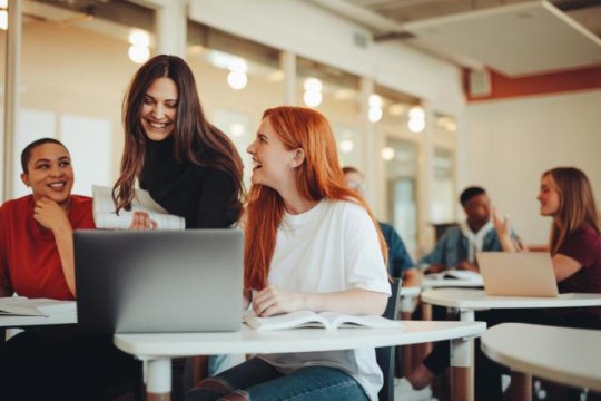 college students at a table smiliing.