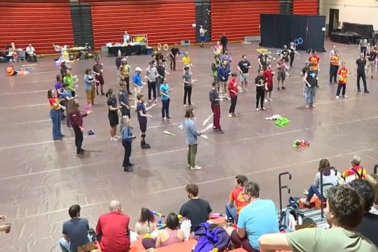 crowd of people juggling in a gym.