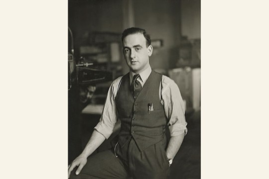 Man posing with press equipment in the background.