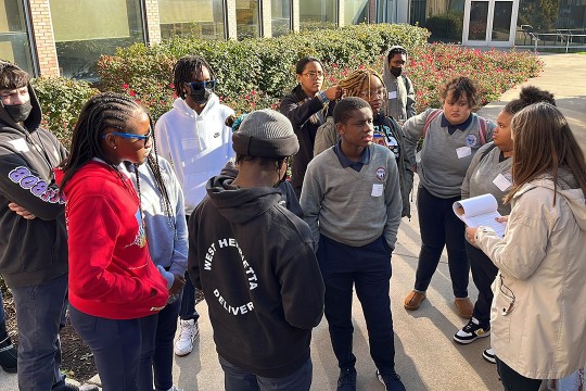 Students gathered at Global Village talking with an RIT employee