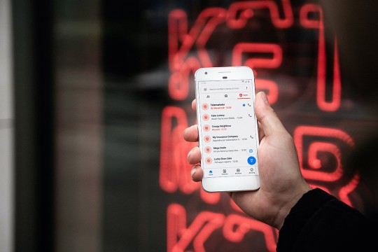 user holding a smart phone showing spam calls.