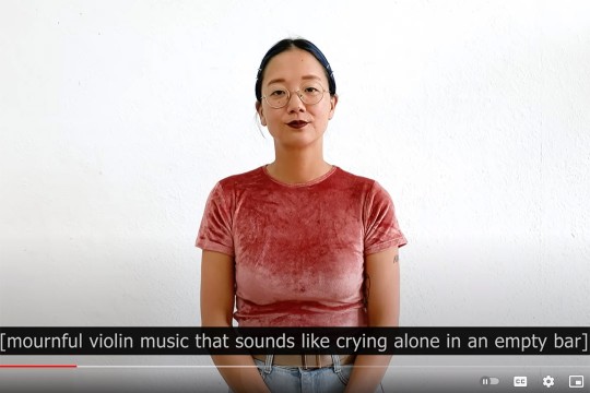 screenshot from You Tube showing a woman standing in front of a white background. The caption reads: mournful violin music that sounds like crying along in an empty bar.