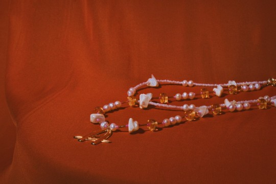 A beaded gemstone necklace set against a red background.