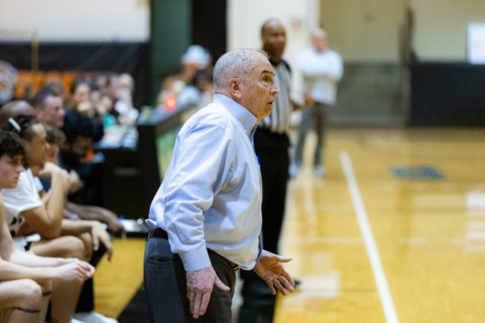 Bob McVean is shown watching a play during a mens basketball game at RIT.