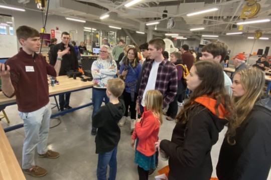 an RIT Student shows his exhibit to festival visitors.