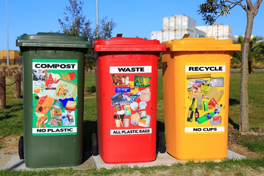 'Three brightly colored waste bins placed where they can easily be found and used .'
