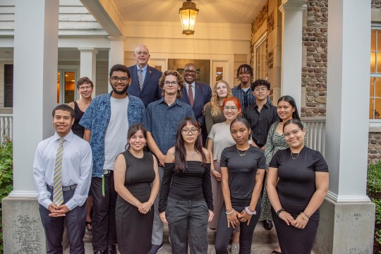 a group of students stand with Dave and Nancy Munson at the entrance to Liberty Hill, the Munsons residence.
