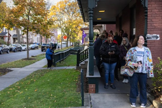 people of all ages stand in a line to vote at the Susan B. Anthony House and Museum. 