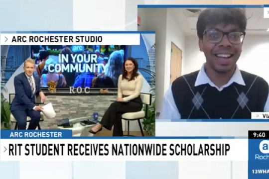 a man and a woman sit on chairs in the lower left of the screen. in the upper right, an R I T student appears to speak to them virtually.