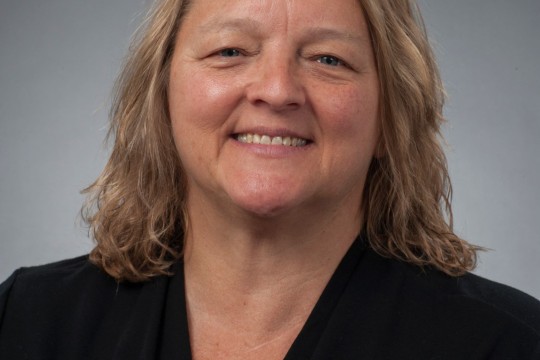 Close up of Pamela Conley wearing a black v-neck top. She is smiling.