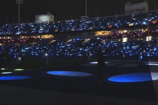 highmark stadium is shown at night, lighted by flashlights